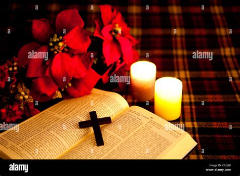 A Crucifix On An Open Bible With Illuminated Candle And Flowers Stock