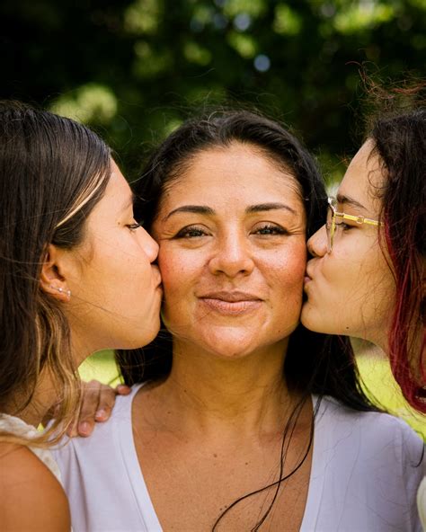 Three Women Kissing Each Other With Their Noses Close Together Photo