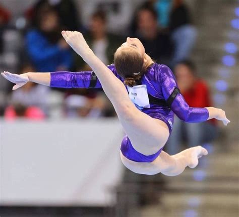 A Woman Is Performing On The Balance Beam