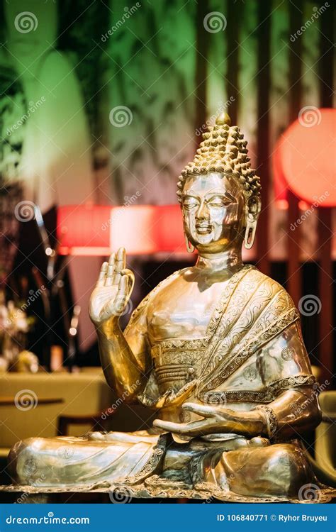 Statue Of Buddha Sitting In Lotus Position With Raised Right Arm Stock