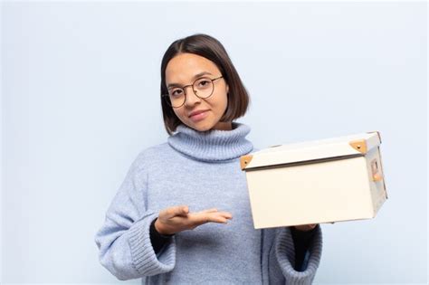 Joven mujer latina sonriendo alegremente sintiéndose feliz y mostrando un concepto en el