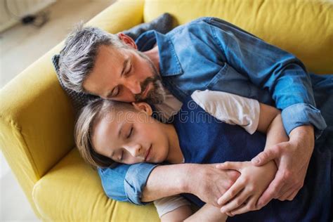 Mature Father With Small Son Lying On Sofa Indoors Sleeping And Resting Stock Image Image Of