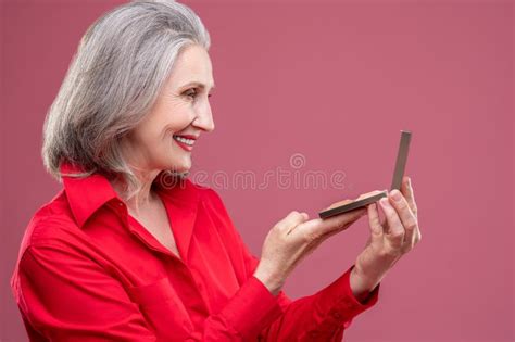 Femme Mature En Rouge Faire Du Maquillage Et Avoir L Air Satisfait Image Stock Image Du