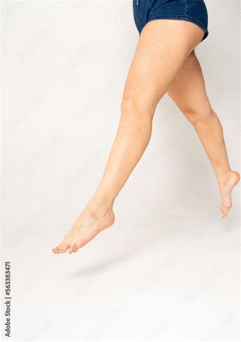 Nude Legs Of A Woman In Hotpants Jumping On A White Background Stock Photo Adobe Stock