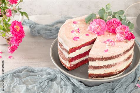 Red Velvet Naked Cake With Fresh Roses And Swiss Buttercream On Kitchen Countertop Stock Photo
