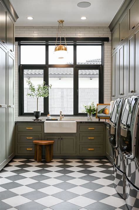 A Kitchen With Black And White Checkered Flooring Green Cabinets And