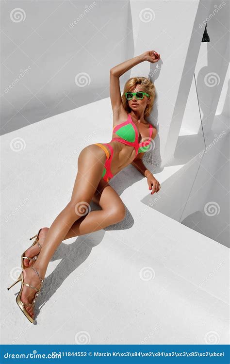 Woman In Bikini On The Sun Tanned Slim And Shapely Body Is Posing Near The Pool In Santorini