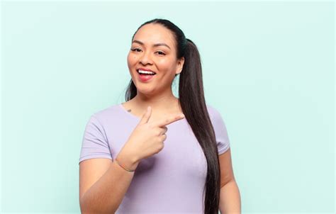Mujer Latina Que Parece Emocionada Y Sorprendida Apuntando Hacia Un Lado Y Hacia Arriba Para