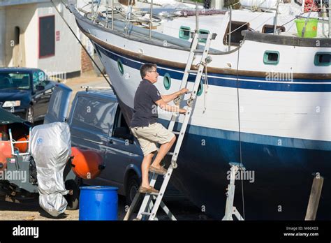 Lhomme De Monter Une échelle Sur Un Bateau Sur Les Stands En Cale