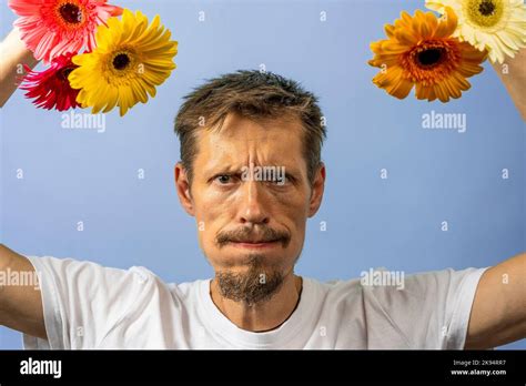 An Angry Irritated Man In A White T Shirt Shakes And Swings Flowers