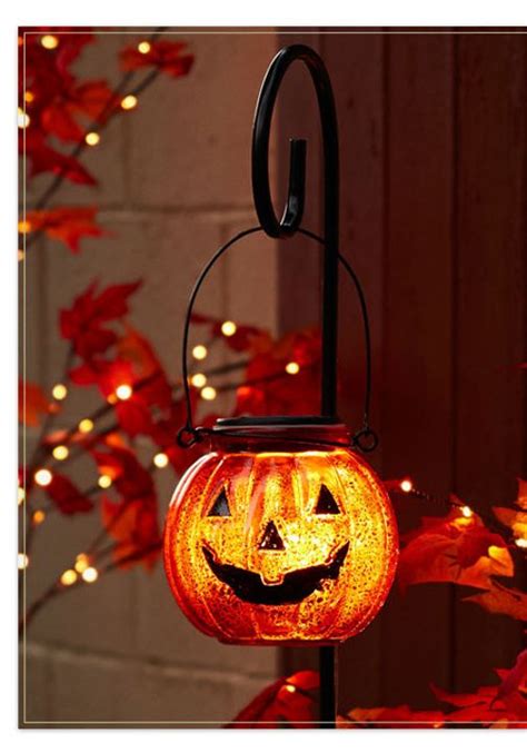 A Lighted Pumpkin Lantern Hanging From A Pole