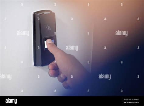 Man Pressing Fingerprint Scanner On Alarm System Indoors Finger Print
