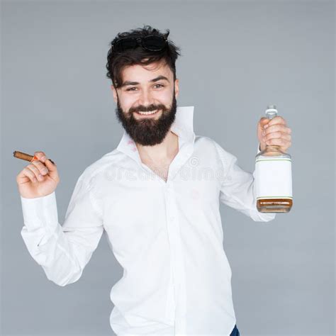 Homme De Sourire Avec La Barbe Tenant Une Bouteille De Whiskey Photo