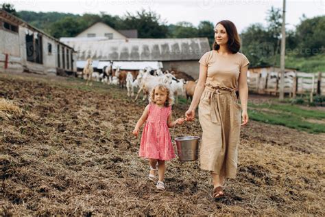 happy mother   daughter spend time   eco farm  goats