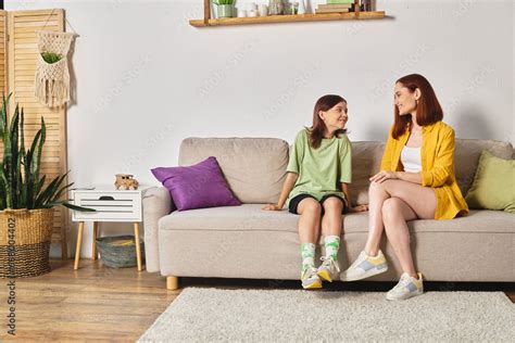 Joyful Mother And Teenage Daughter Talking About Sex Education On Couch In Living Room At Home