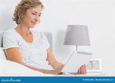 Content Blonde Woman Sitting In Bed Using Tablet Pc Stock Photo Image Of Computer Happy 33051386