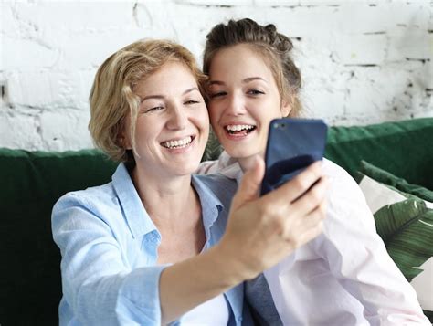 Premium Photo Portrait Of Beautiful Mature Mother And Her Daughter Making A Selfie Using Smart