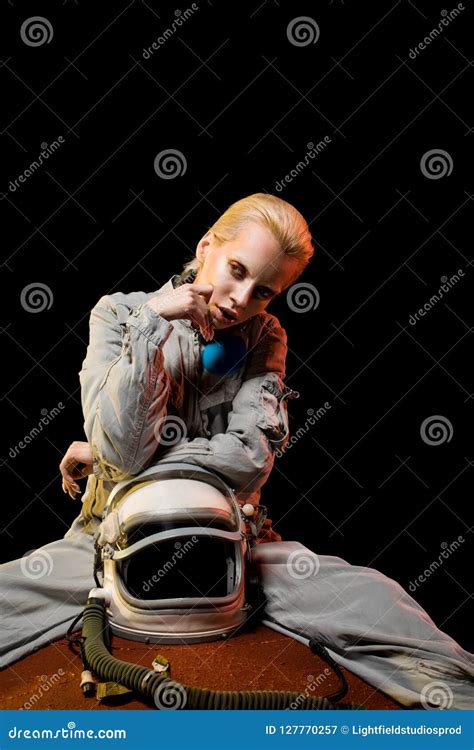 Stylish Astronaut In Spacesuit Holding Helmet Sitting On Planet Stock