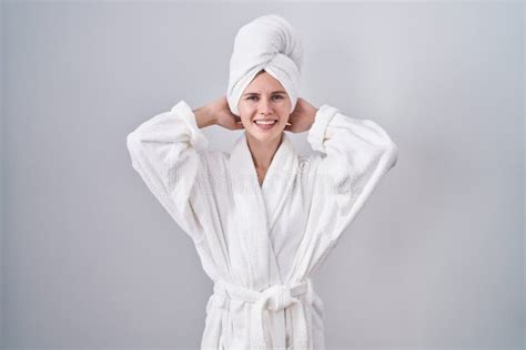 Blonde Caucasienne Femme En Peignoir Relaxant Et étirant Les Bras Et Les Mains Derrière La Tête