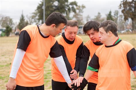 Team Of Soccer Players With Down Syndrome Cheering Up At Field Stock