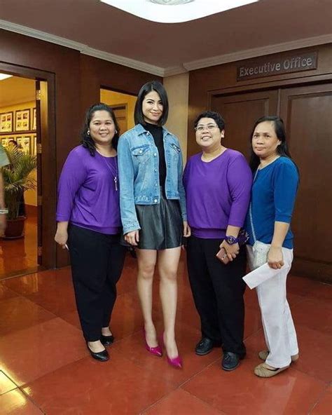 Three Women In Purple Shirts And Black Pants Are Posing For A Photo