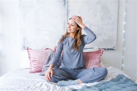 Happy Young Woman Sitting In Comfortable Bed Arms Outstretched After