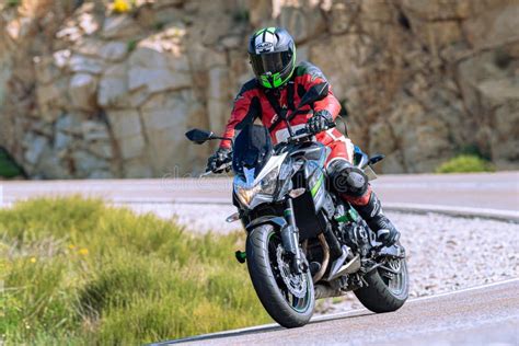 Motorcyclist Riding On His Motorcycle On The Road Taking A Sharp Curve