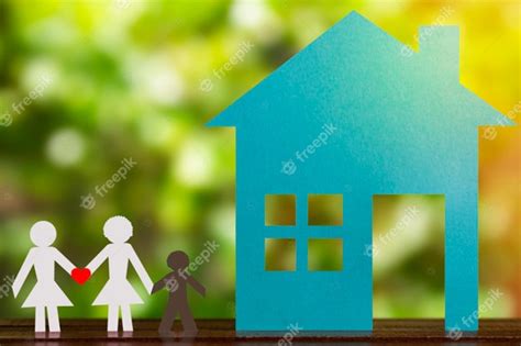 Figura de papel de um casal gay de mãos dadas o filho adotivo casa azul e fundo desfocado