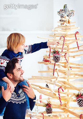 Happy Father And Son Decorate An Extraordinary Christmas Tree Made Of