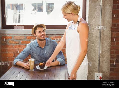 Smiling Blonde Waitress Serving Muffin To Handsome Hipster Stock Photo Alamy