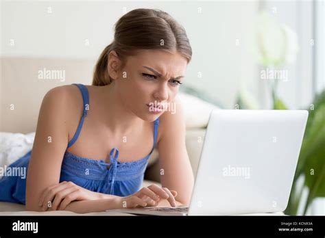 Confused Young Woman Having Problem With Computer Looking At Laptop