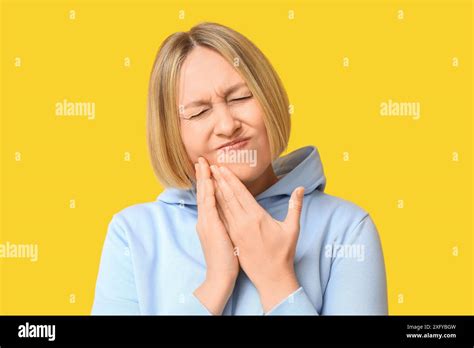 Beautiful Mature Woman Suffering From Toothache On Yellow Background Stock Photo Alamy