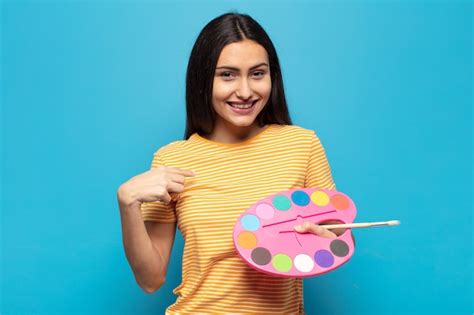 Joven latina que se siente feliz sorprendida y orgullosa señalando a sí misma con una mirada