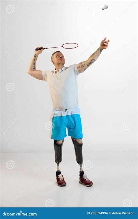 Full Length Of Nice Positive Man With Prosthesis Play Badminton Indoors