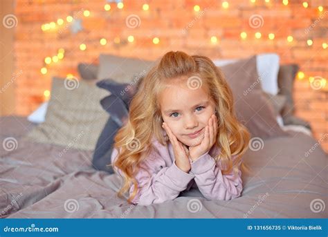 Mooi Meisje Met Blonde Krullen In Verwachting Van Giften In De Achtergrondkerstmislichten En Het