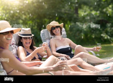 Three Mature Women Relaxing In Sun Loungers Drinking Wine Stock Photo Alamy