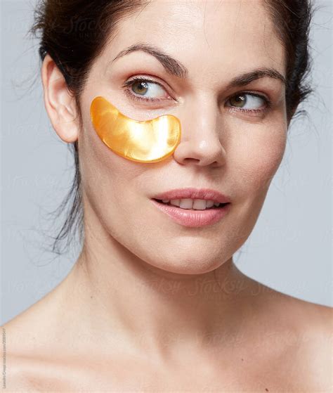 Woman Using Gel Eye Patch Mask By Stocksy Contributor Ohlamour