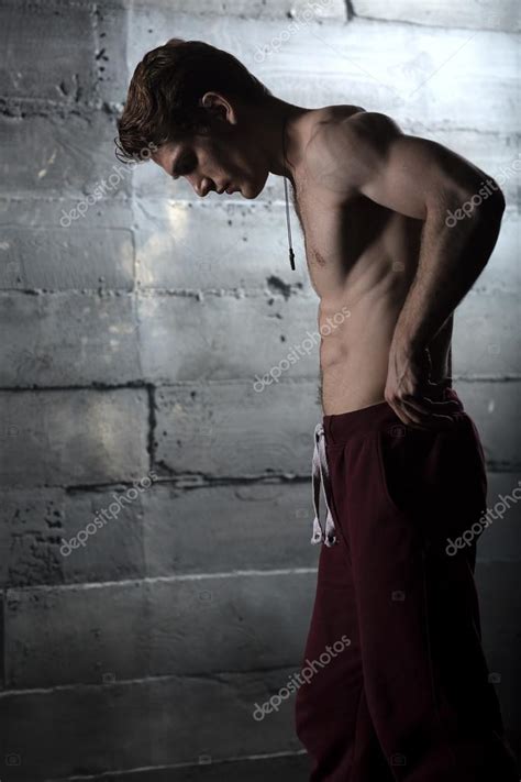 Handsome Athlete With A Naked Torso Adjusts His Pants The Pictu Stock Photo By Bezikus