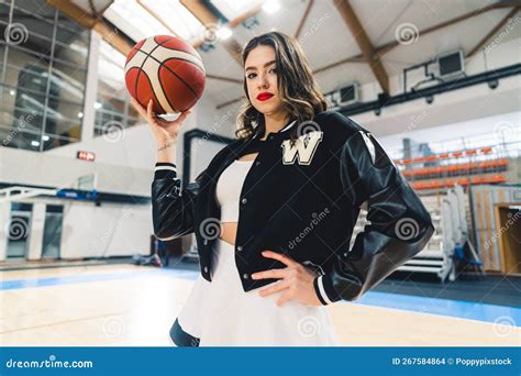 Side Bottom View Of Brunette Cheerleader In Black Jumper Holding A Basketball In Her Hand The