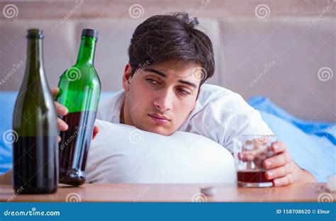 Man Alcoholic Drinking In Bed Going Through Break Up Depression Stock