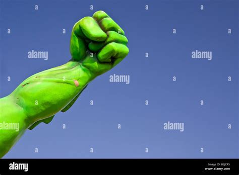 The bright green arm and fist of a giant creature attached to a tourist ...