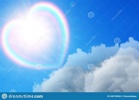 Beautiful View Of Heart Shaped Cloud With Rainbow In Blue Sky On Sunny