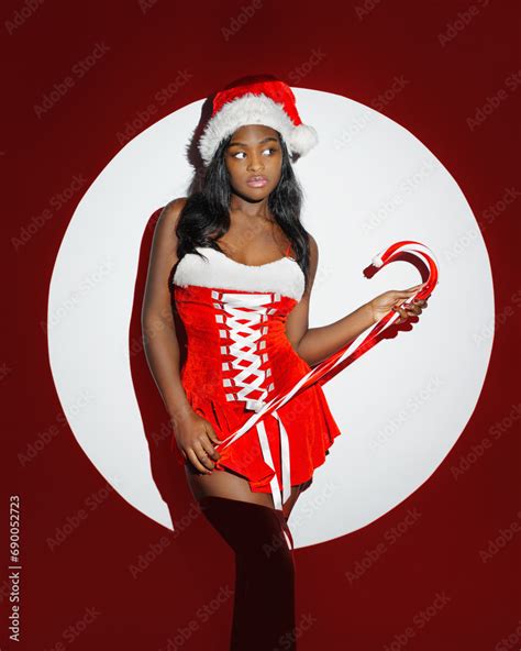 Sexy African American Girl In Red Santa Claus Costume Is Holding Christmas T In Spot Stock