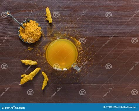 Herbal Tea With Turmeric Powder And Turmeric Roots On A Brown Table