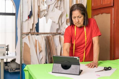 Mujer Que Usa Una Tableta Digital Mientras Trabaja En Una Mesa De Corte