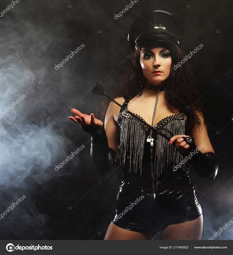 Sexy Brunette Woman Mistress Holding Whip Over Dark Backgrouynd With