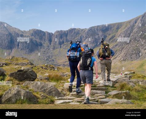 People hiking on a footpath to Cwm Idwal with Devil's Kitchen beyond in Snowdonia National Park ...