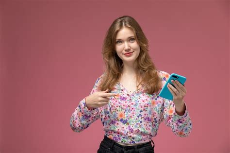 Vue de face femme blonde montre son nouveau téléphone portable Photo Gratuite