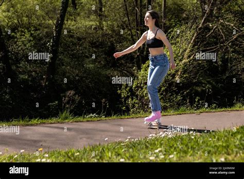 Brunette Woman Skating In The Park With Pink Roller Skates Stock Photo Alamy