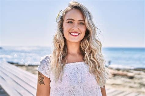 Jeune Fille Blonde Souriante Heureuse Debout à La Plage Photo Gratuite
